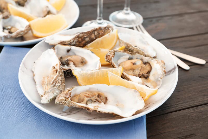 Fresh oysters with cut juicy lemon served stock photo