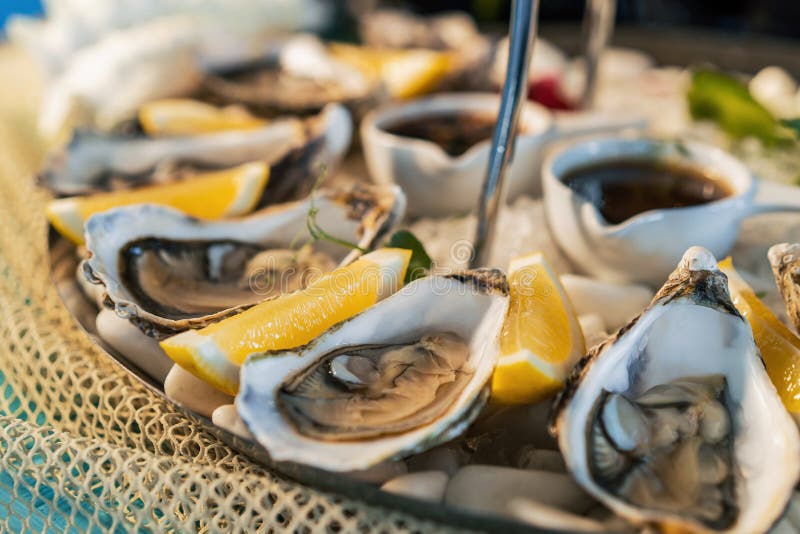 Fresh Oysters with Lemon on White Plate in Restaurant Stock Image