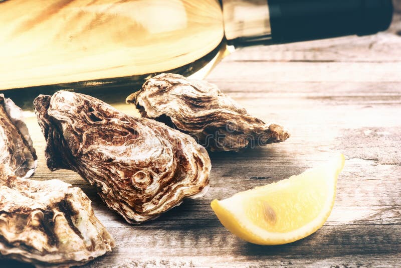 Oysters in a White Plate with Lemon and a Glass of Wine on a Wooden Table Stock Image Image of