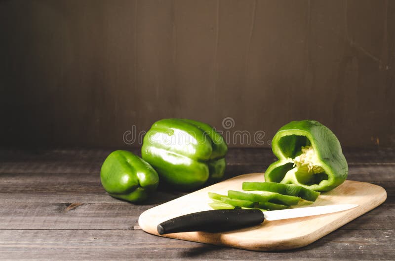 fresh paprika cut on a wooden board on a dark background/green pepper paprika cut on a wooden board, selective focus royalty free stock photo fresh paprika cut on a wooden board on a dark background/green pepper paprika cut on a wooden board, selective focus royalty free stock photo