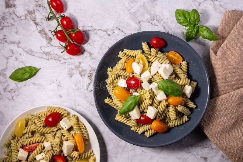 Fresh Pesto Pasta Salad with Tomatoes and Mozzarella Stock Photo