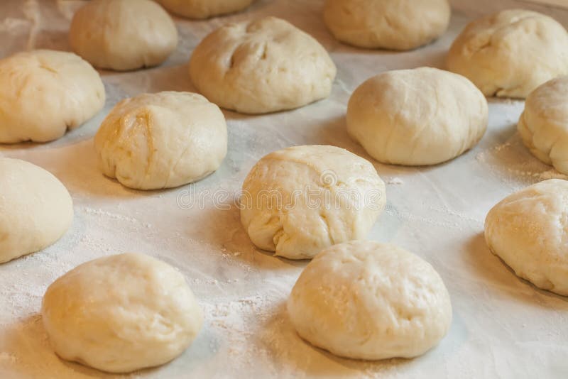 Fresh Pieces of Raw Dough with Flour on the Table in the Kitchen Stock