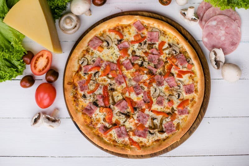 Fresh pizza surrounded by ingredients on light wooden background royalty free stock images Fresh pizza surrounded by ingredients on light wooden background royalty free stock images