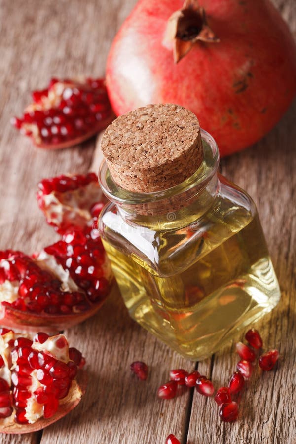 Fresh pomegranate seed oil in a glass bottle macro. vertical