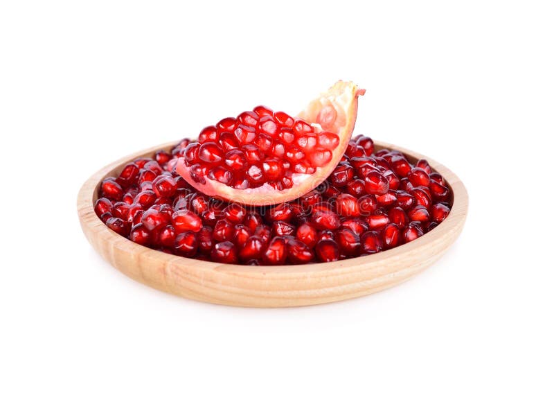 fresh pomegranate seed with shell in wooden plate on white background