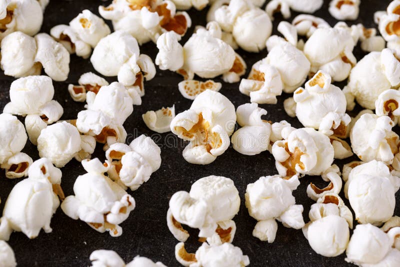 Fresh popcorn close up on black table