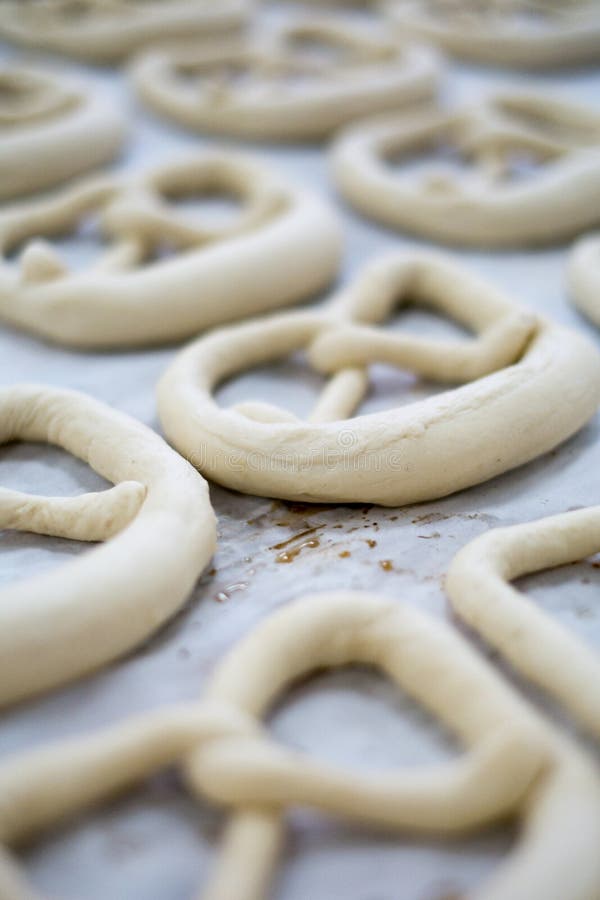 Fresh Pretzel Dough on a baker's sheet sitting on wax paper. Raw uncooked but looking delicious as a mirrored brezel or Breze. Fresh Pretzel Dough on a baker's sheet sitting on wax paper. Raw uncooked but looking delicious as a mirrored brezel or Breze.