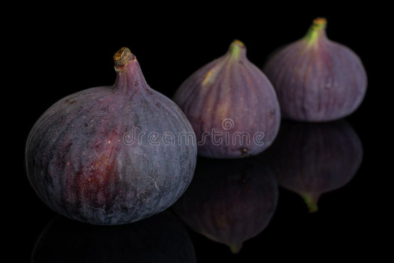 Fresh purple fig isolated on black glass