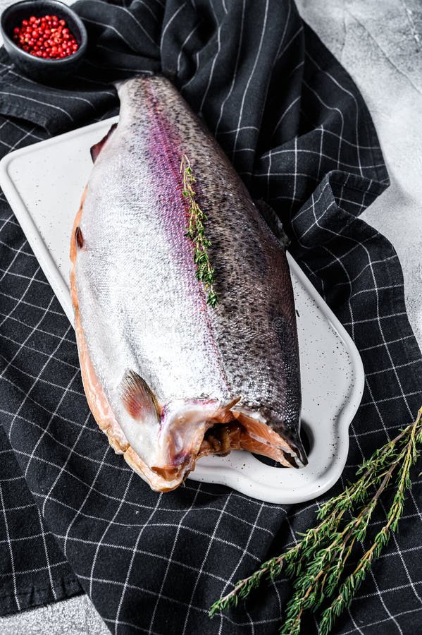 Fresh Rainbow Trout Fish Marinated with Salt and Thyme. Gray Background