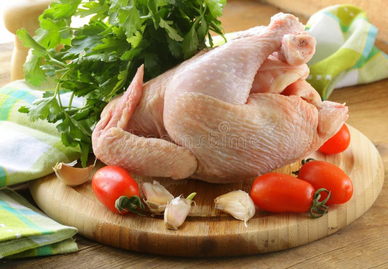 Fresh Raw Chicken on a Cutting Board with Vegetables Stock Photo