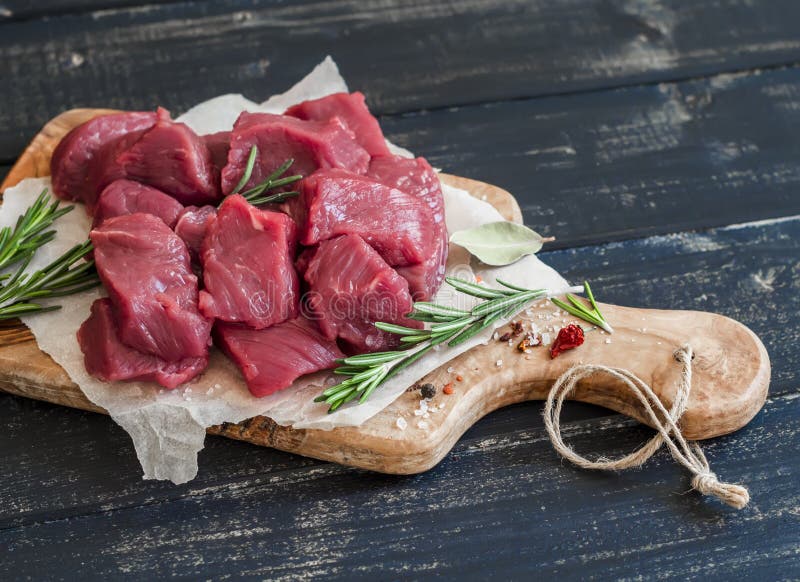 Fresh raw chopped beef, spices and herbs on an olive board royalty free stock images Fresh raw chopped beef, spices and herbs on an olive board royalty free stock images