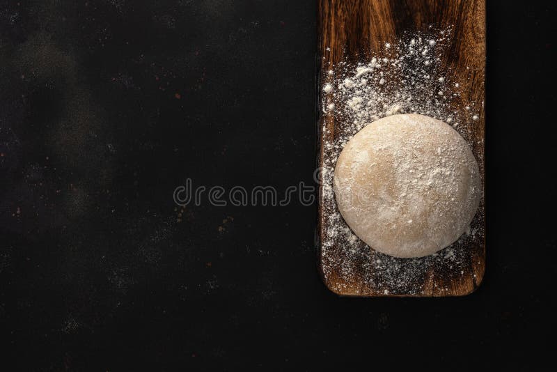 Fresh raw dough for bread or pizza on a rustic wooden background with dusting of flour. Top view. Raw fresh yeast dough stock images, royalty-free photos and pictures