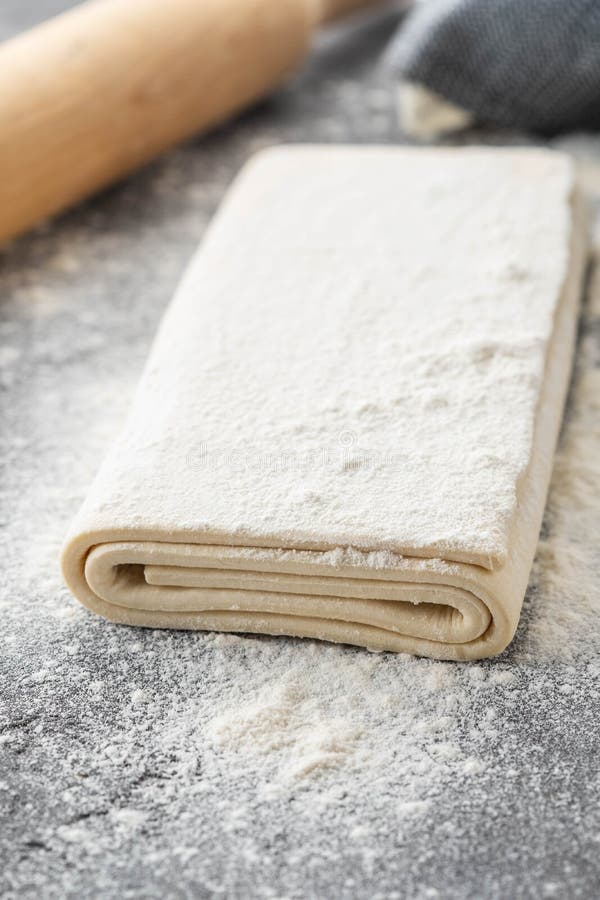 Fresh raw dough on table. Puff pastry. Copy space.