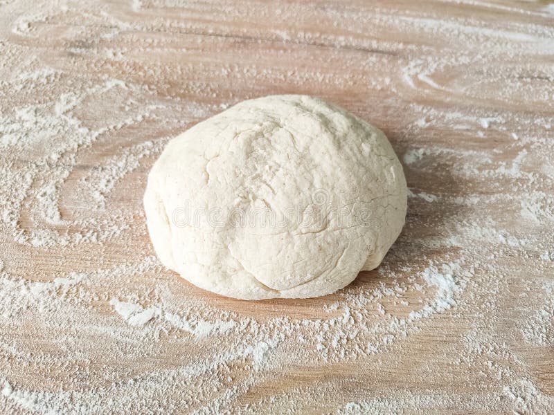 Fresh raw dough on wooden table covered with flour. Top view. Raw fresh yeast dough stock images, royalty-free photos and pictures