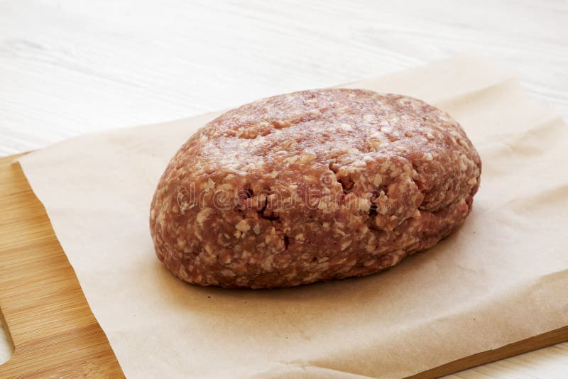 Fresh Raw Grass Fed Ground Beef on a Bamboo Board, Side View. Closeup