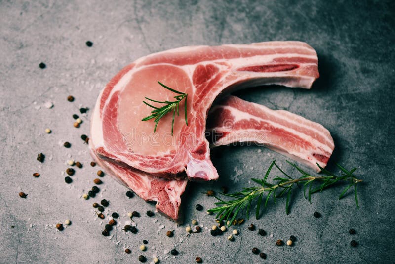 Fresh raw pork chops steak with herb and spices - Fresh meat pork sliced on black background