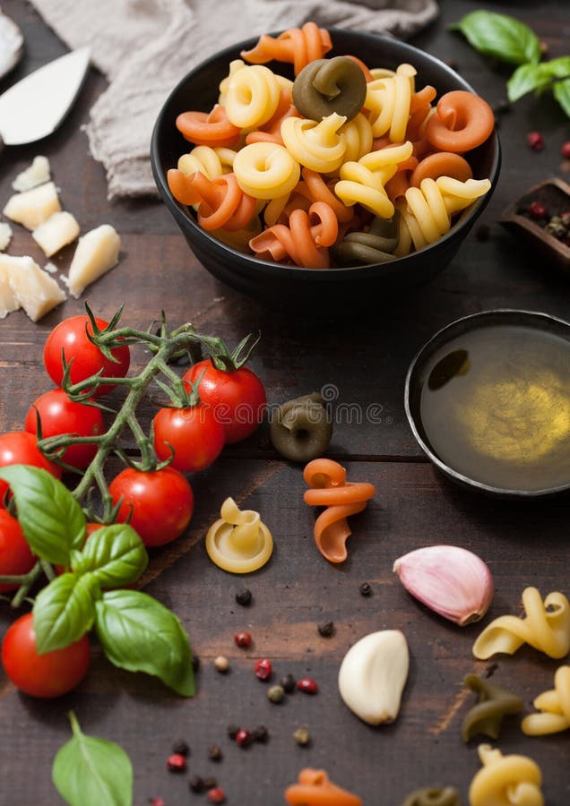 Fresh Raw Tricolore Trottole Pasta in Black Bowl with Cherry Tomatoes ...