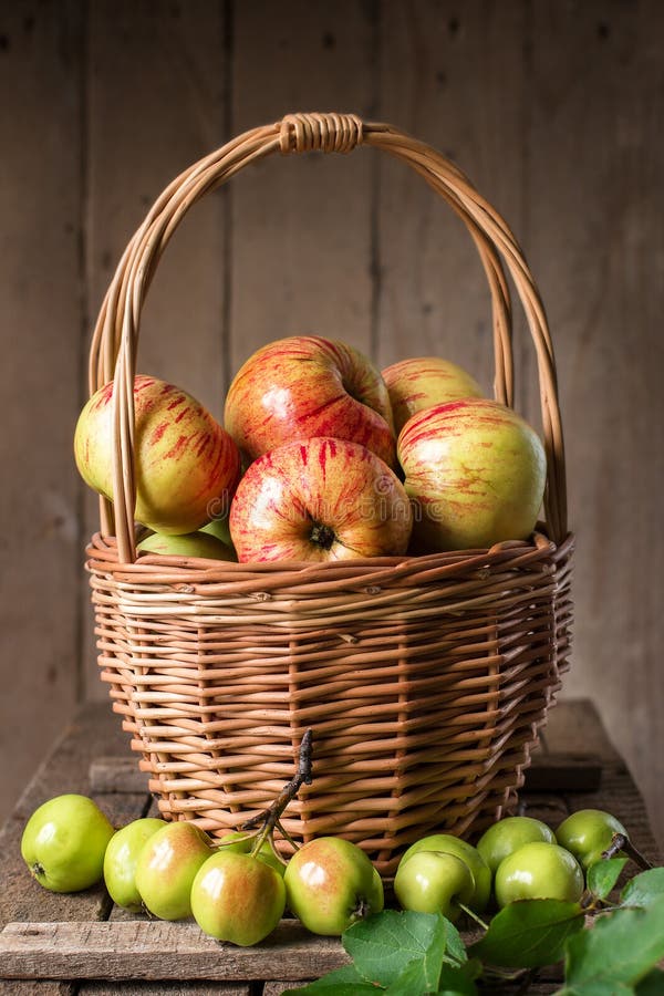 Fresh ripe apples in basket on rustic table