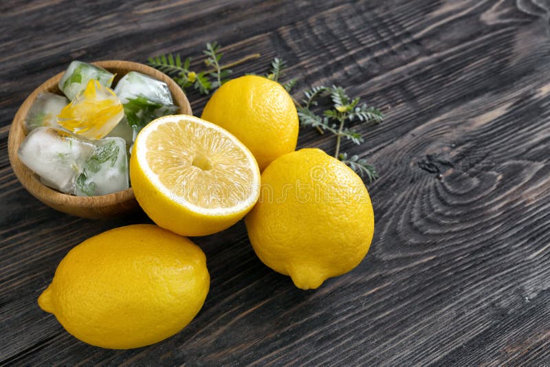 Fresh ripe lemons with ice cubes on wooden background stock photography Fresh ripe lemons with ice cubes on wooden background stock photography