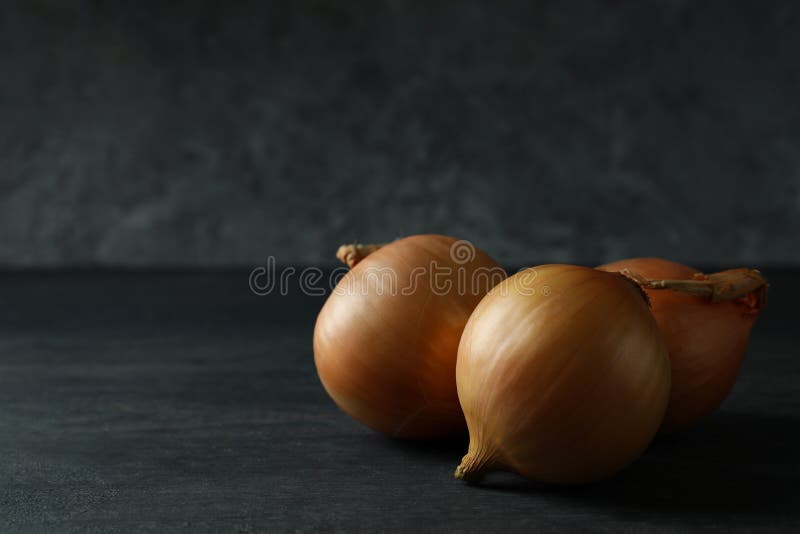 Fresh ripe onion on black wooden table