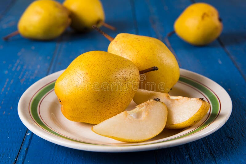 Fresh ripe organic yello pears on blue rustic wooden table, natural background, diet food. Nutrition, fruit.