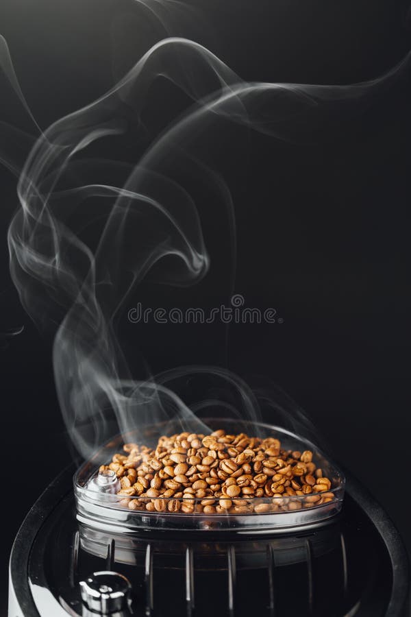 Fresh Roasted Coffee Beans with Smoke in Coffeemaker Bean Container