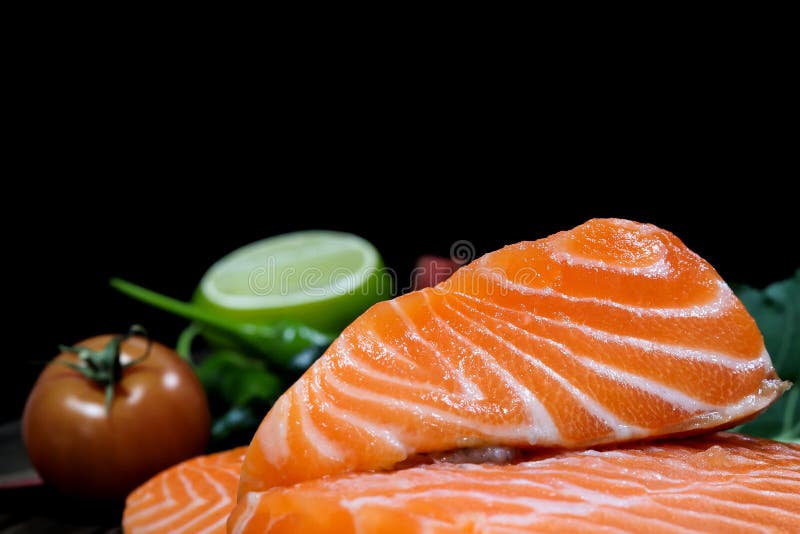 Fresh salmon with spices on the table, garlic, tomato and lemon royalty free stock photography.