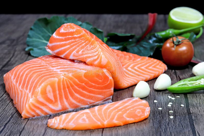 Fresh salmon with spices on the table, garlic, tomato and lemon stock photos
