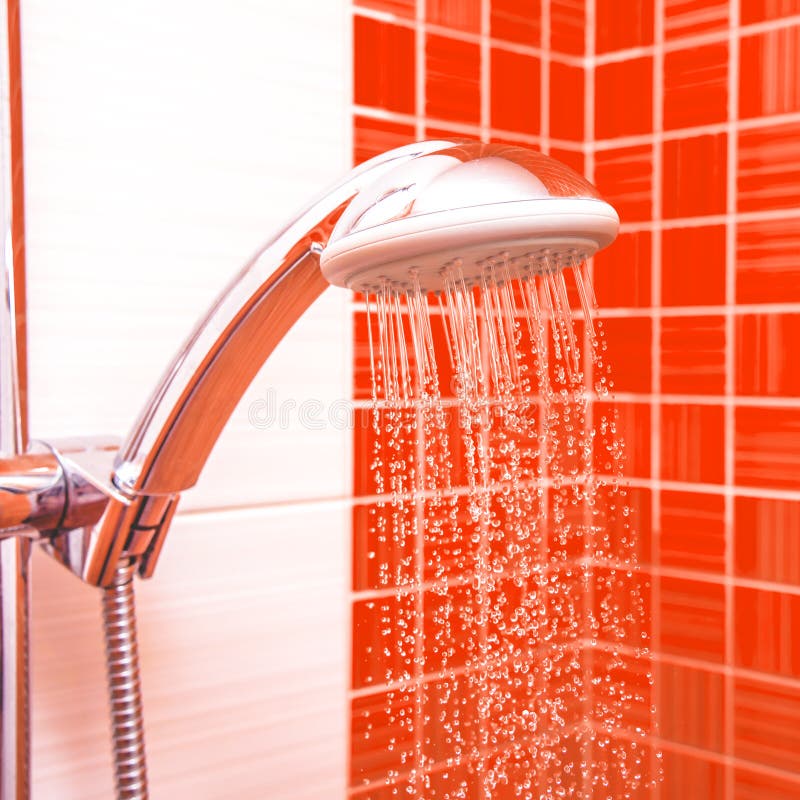 Fresh shower where Water running from shower head and faucet in modern bathroom with orange wall stock image Fresh shower where Water running from shower head and faucet in modern bathroom with orange wall stock image