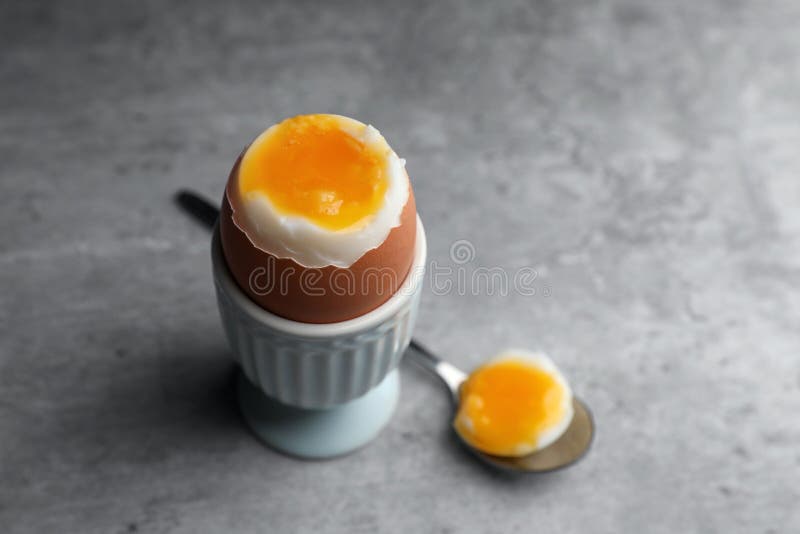 Fresh Soft Boiled Egg in Cup on Grey Table. Space for Text Stock Photo