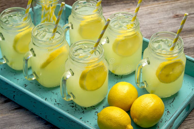 Seis vaso tazas lleno frío fresco limonada bebidas entero limón rebanadas sobre el de madera mesa.