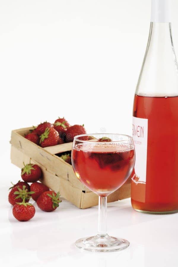 Fresh strawberries in basket and strawberry wine in glass