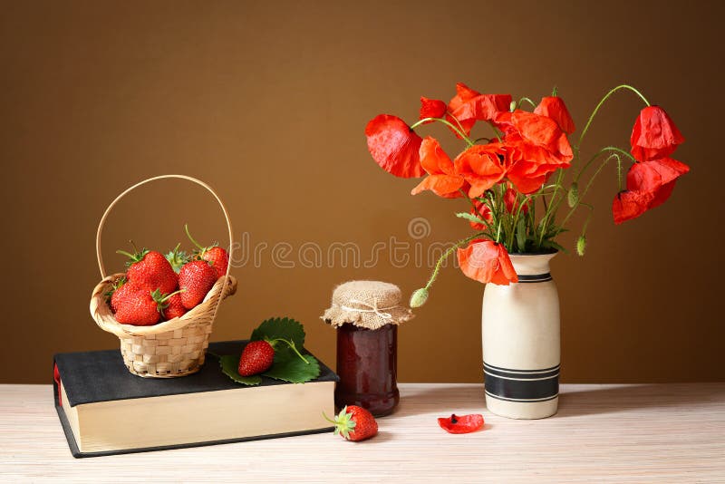 Fresh strawberry jam in a jar and poppies