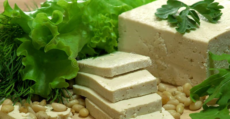 Fresh Tofu. Sliced fresh tofu with greens and cedar nuts royalty free stock photo