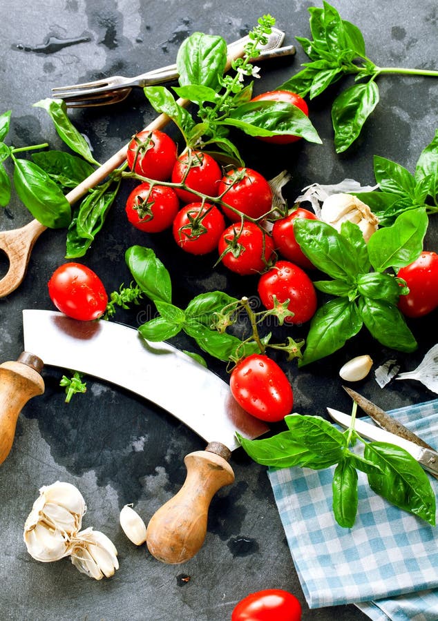 Fresh tomatoes with basil garlic and sea salt on black slate background royalty free stock image Fresh tomatoes with basil garlic and sea salt on black slate background royalty free stock image
