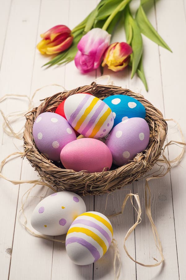 Fresh tulips and colorful easter eggs in a nest