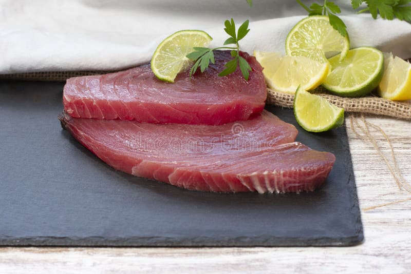 Fresh Tuna Fillets by Citrus and on Black Stone Image