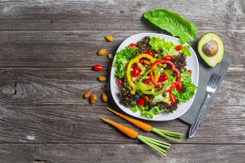 Fresh vegetable salad on wood table background, top view