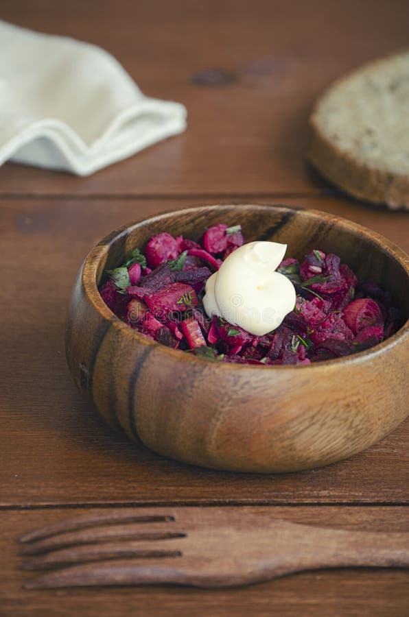 Fresh vegetable vegetarian salad with sauce in wooden bowl with wooden fork on wooden table, Russian salad vinaigrette, closeup 45 royalty free stock image Fresh vegetable vegetarian salad with sauce in wooden bowl with wooden fork on wooden table, Russian salad vinaigrette, closeup 45 royalty free stock image