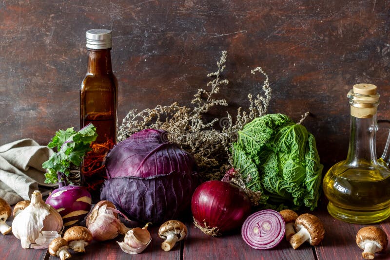 Fresh vegetables on a wooden background. Stillife. Onions, mushrooms, cabbage, garlic, olive oil Healthy food Vegetarianism, diet, organic, agriculture, natural, tomato, salad, pepper, red, market, autumn, green, basket, kitchen, farm, summer, eggplant, cooking, rural, yellow, color, copy, herb, gourd, orange, group, recipe, art, nature, isolated, eat, season, text, restaurant, raw, harvest, corn