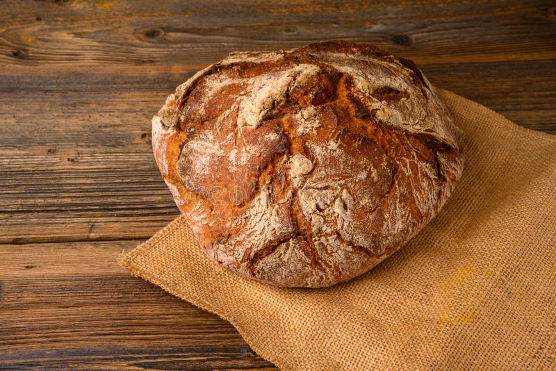 A Fresh Whole Grain Bread from the Baker on a Jute Fabric Stock Image