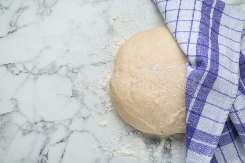 Fresh Yeast Dough with Flour on White Marble Table, Top View. Space for