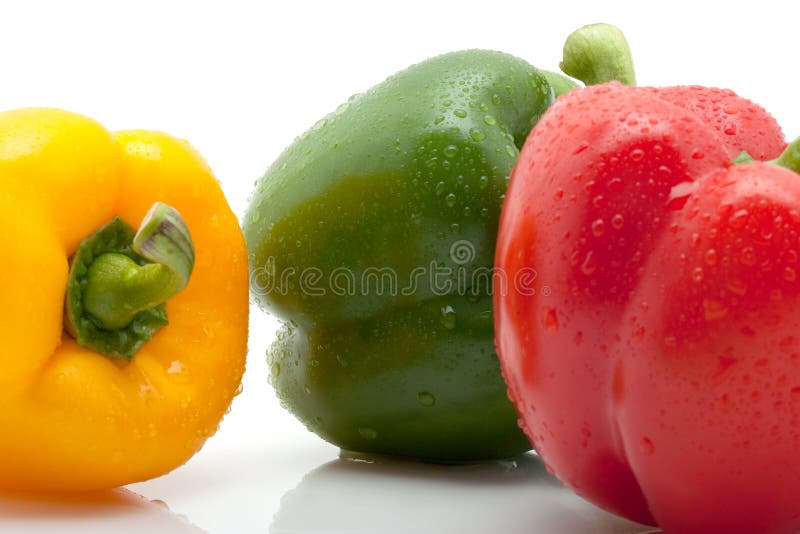 Fresh yellow, orange and green pepper with water drops isolated on white background