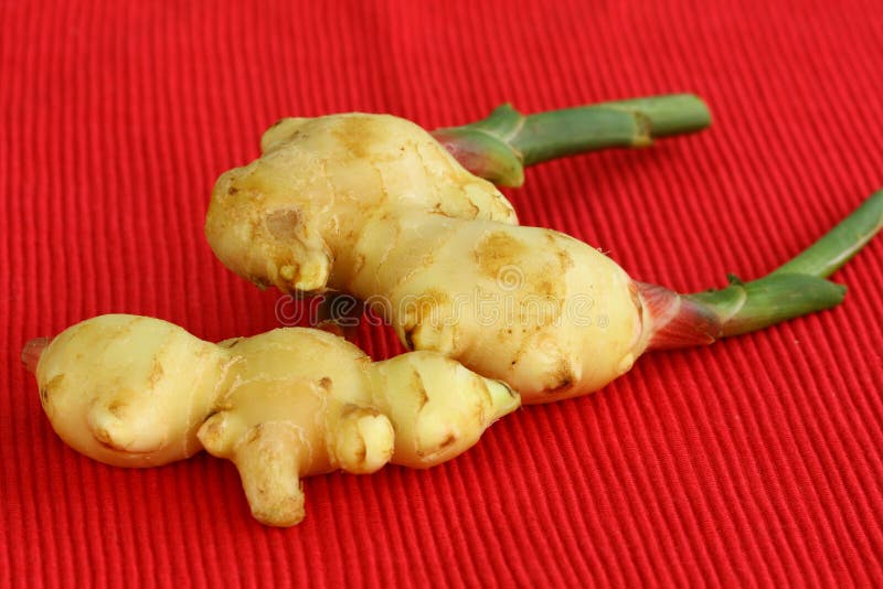 Fresh ginger on red background