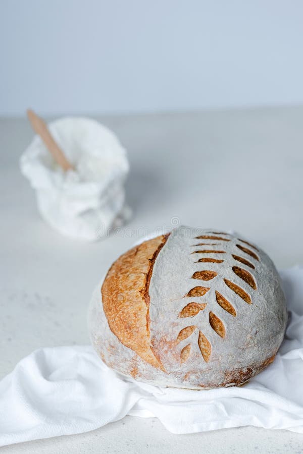 Freshly Baked Artisan Sourdough Bread Loaves and Bag of Flour on White