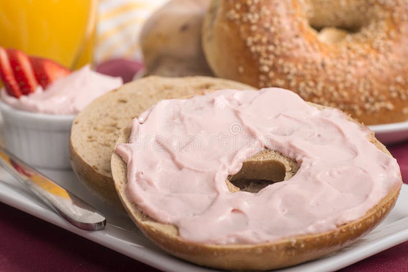 Freshly baked bagel with strawberry cream cheese, orange juice a. Freshly made sesame bagel with strawberry cream cheese, orange juice and ripe sliced stock image Freshly baked bagel with strawberry cream cheese, orange juice a. Freshly made sesame bagel with strawberry cream cheese, orange juice and ripe sliced stock image