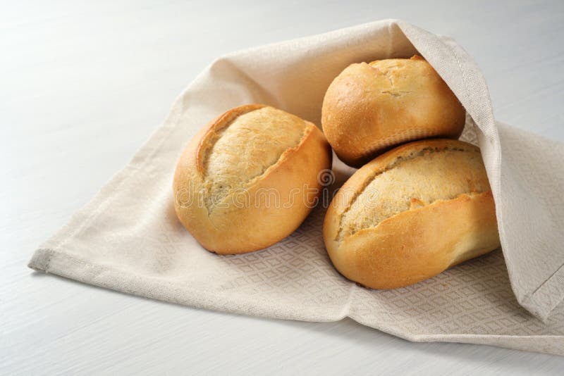 Freshly Baked Bread Rolls or Buns from the Baker in a Kitchen Towel on