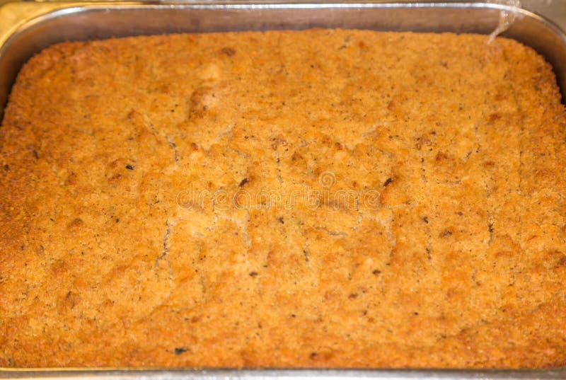 Batch of freshly baked cornbread dressing for sale or serving at a restaurant deli.