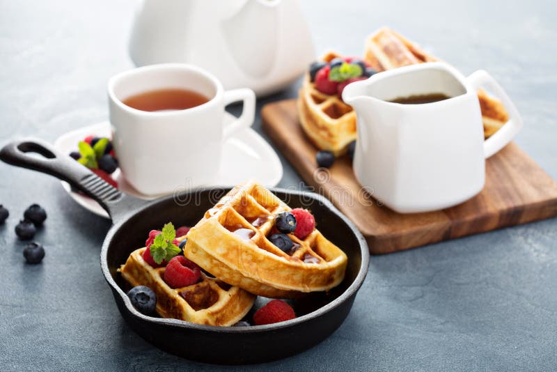 Freshly baked waffles with berries and tea for breakfast