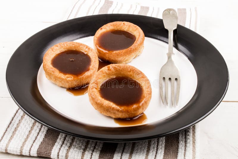 Freshly Baked Yorkshire Pudding with Gravy on a Plate Stock Photo